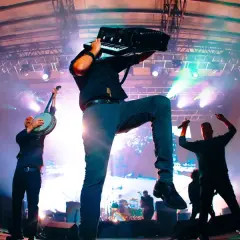 Muzycy Dropkick Murphys grający na banjo i akordeonie na scenie podczas koncertu.