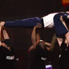 Tommy Cash lewituje na scenie, podtrzymywany przez ochronę.