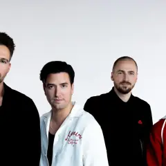 Czterech mężczyzn z zespołu Big Time Rush pozuje do zdjęcia na białym tle.