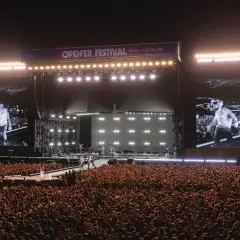 Tłum szaleje na opener festiwal w sobotę. Na scenie artyści, a na telebimach ich wizerunki.