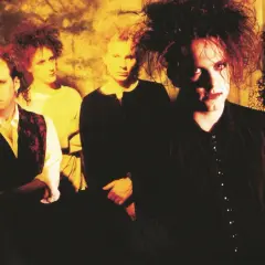 Zespół The Cure w charakterystycznych fryzurach i makijażu. Ich mroczne utwory niosą emocje.