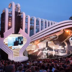 Scena Festiwalu Opole z widownią i charakterystyczną wieżą w tle. Widać elementy programu i artystów.