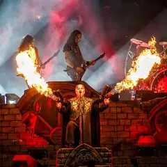 Płomienie i dym na koncercie Powerwolf. Wokalista z miotaczami ognia, gitarzyści i perkusista w akcji.