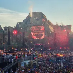 Tłum ludzi na jednym z największych festiwali muzycznych w Europie. Na scenie wulkanicznej wyświetlane jest imię Steve Angello, a nad głowami publiczności latają czerwone konfetti.