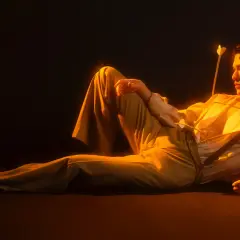 Conan Gray w stylizacji inspirowanej romantyzmem, z dwoma strzałami w klatce piersiowej, jakby po koncercie.