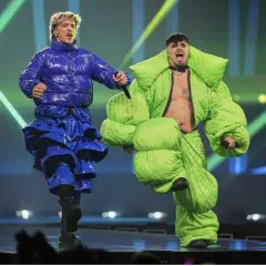 Dwóch artystów w jaskrawych, obszernych strojach na scenie.