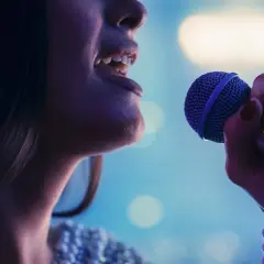 Kobieta śpiewa do mikrofonu. Czy to playback? Nie, czuć emocje w jej głosie.