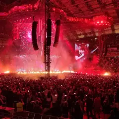 Koncert Dawida Podsiadło w Poznaniu: scena z ogniem, tłum ludzi i ekrany z artystą.