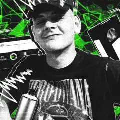Młody mężczyzna w czapce i koszulce z napisem, obok kaset VHS i magnetofonowych, na tle zielonych abstrakcyjnych wzorów.
