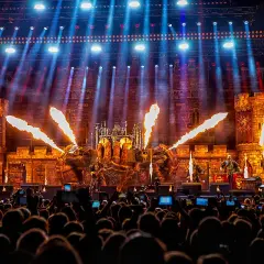 Koncert Sabaton z pirotechniką i scenografią zamku, widziany z perspektywy publiczności.
