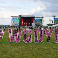 Różowe litery #WGDYNI na trawie przed sceną festiwalową Open'er.