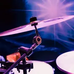 Talerze perkusyjne w fioletowym świetle, gotowe do zagrania utworów zespołu black midi.