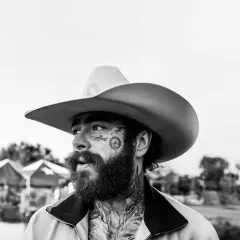 Post Malone w kowbojskim kapeluszu, z tatuażami na twarzy, gotowy na swój kolejny koncert.