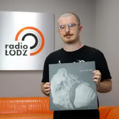 Mężczyzna w okularach trzyma płytę winylową The Cure "Songs of a Lost World" na tle logo Radia Łódź.