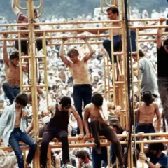 Ludzie wspinający się na żółtą konstrukcję podczas festiwalu Woodstock 1969.