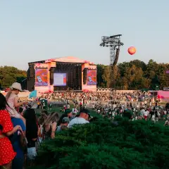 Tłum ludzi na festiwalu Bittersweet, scena w tle, różowe dekoracje i balon unoszący się na niebie.
