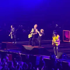 Zespół Guns N' Roses na scenie podczas koncertu w Gliwicach, w tle publiczność.