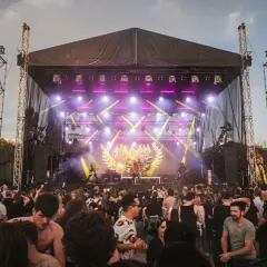 Koncertowa noc na 3 majówce! Zespół gra na scenie, a tłum bawi się pod nią.