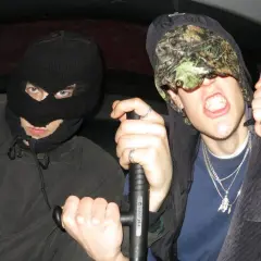 Dwóch mężczyzn w kominiarkach, jeden trzyma tonfę. Ich styl to czysty tonfa rap.