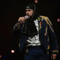 Bad Bunny w ozdobnej marynarce śpiewa na koncercie, marząc o występie w Polsce.