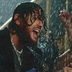 James Arthur śpiewa w deszczu w Warszawie, grając na gitarze.