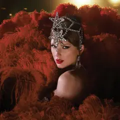 Taylor Swift w teatralnej kreacji z piór i biżuterii. Zastanawiasz się, ile piosenek ma Taylor Swift?