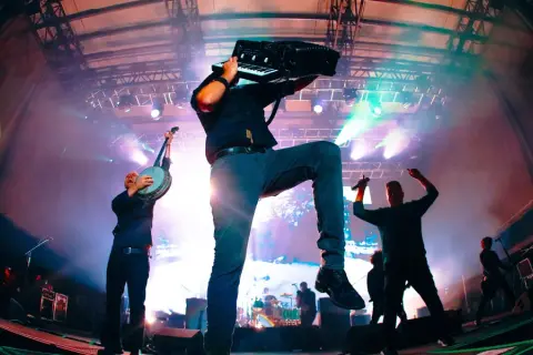 Muzycy Dropkick Murphys grający na banjo i akordeonie na scenie podczas koncertu.