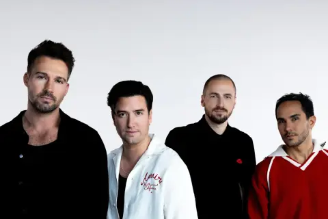 Czterech mężczyzn z zespołu Big Time Rush pozuje do zdjęcia na białym tle.