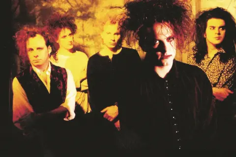 Zespół The Cure w charakterystycznych fryzurach i makijażu. Ich mroczne utwory niosą emocje.