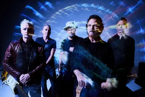 Zespół Pearl Jam Polska w stylizacji z lat 90. na tle psychodelicznych wizualizacji.