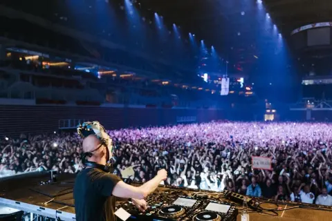 DJ Boris Brejcha w masce gra dla tłumu fanów na koncercie w hali.