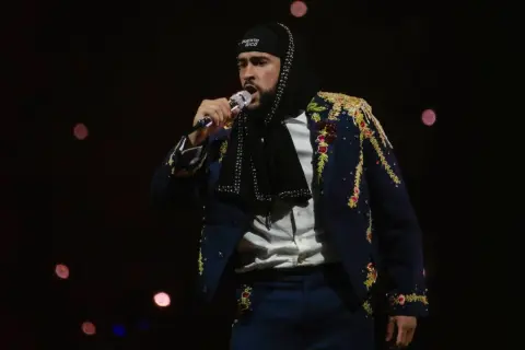 Bad Bunny w ozdobnej marynarce śpiewa na koncercie, marząc o występie w Polsce.