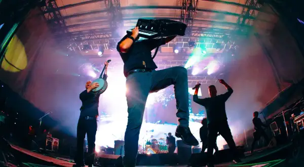 Muzycy Dropkick Murphys grający na banjo i akordeonie na scenie podczas koncertu.