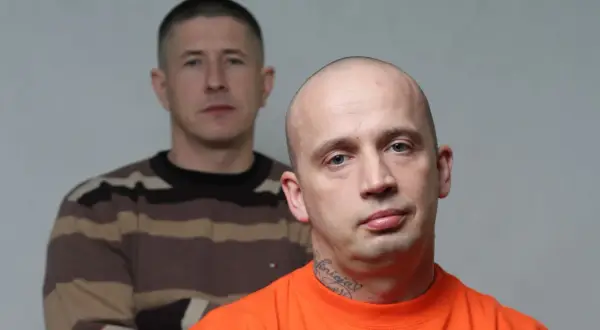Dwóch mężczyzn, jeden z przodu w pomarańczowej koszulce i tatuażem na szyi, drugi z tyłu w bluzie w paski.