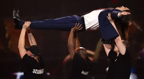 Tommy Cash lewituje na scenie, podtrzymywany przez ochronę.