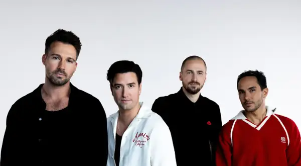 Czterech mężczyzn z zespołu Big Time Rush pozuje do zdjęcia na białym tle.