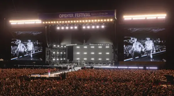Tłum szaleje na opener festiwal w sobotę. Na scenie artyści, a na telebimach ich wizerunki.