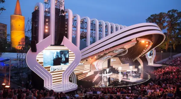 Scena Festiwalu Opole z widownią i charakterystyczną wieżą w tle. Widać elementy programu i artystów.
