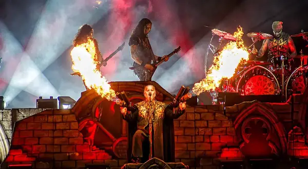 Płomienie i dym na koncercie Powerwolf. Wokalista z miotaczami ognia, gitarzyści i perkusista w akcji.