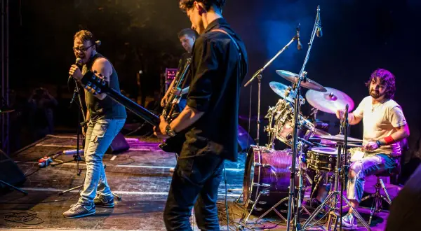 Zespół grający na żywo, wokalista śpiewa do mikrofonu, gitarzyści na scenie, perkusista za zestawem. Klimat jak z najlepszych zespołów lat 80.