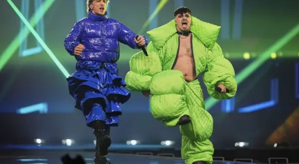 Dwóch artystów w jaskrawych, obszernych strojach na scenie.