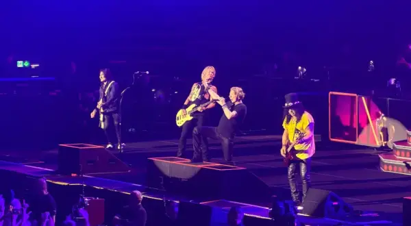Zespół Guns N' Roses na scenie podczas koncertu w Gliwicach, w tle publiczność.