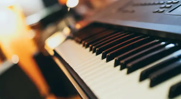 Zbliżenie na klawisze keyboardu. Widoczne białe i czarne klawisze, gotowe do zagrania melodii.