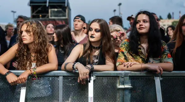 Młode kobiety z bransoletkami i naszyjnikami, czekające na koncert podczas krakowskiego festiwalu muzycznego.