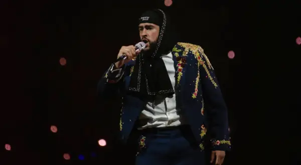 Bad Bunny w ozdobnej marynarce śpiewa na koncercie, marząc o występie w Polsce.