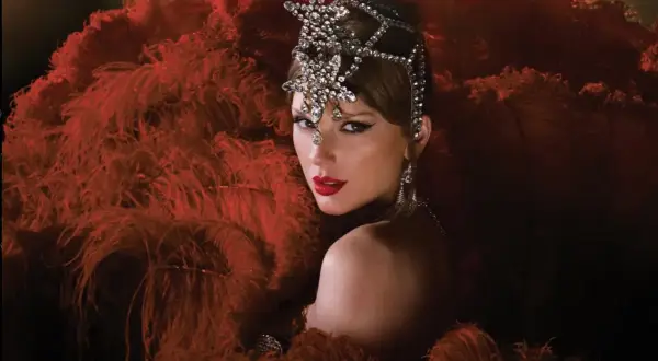 Taylor Swift w teatralnej kreacji z piór i biżuterii. Zastanawiasz się, ile piosenek ma Taylor Swift?