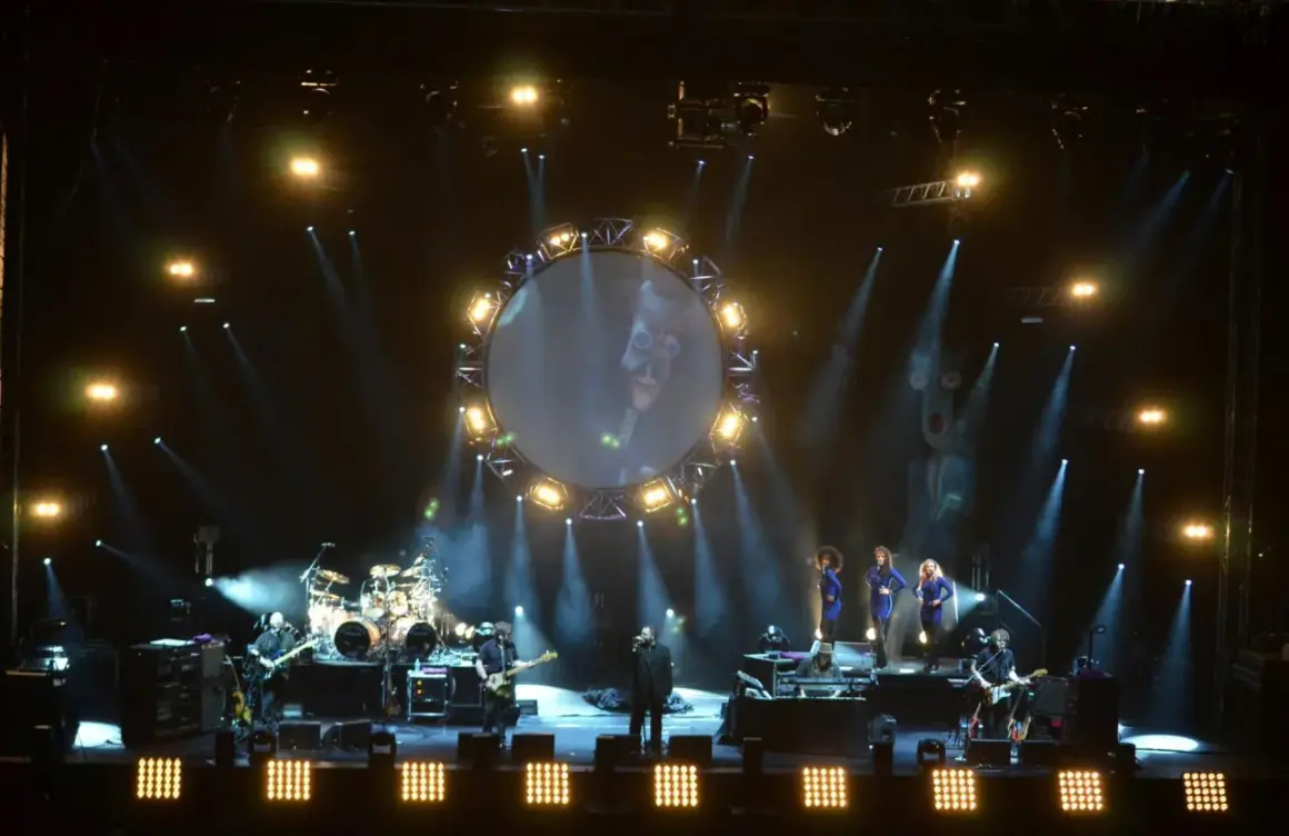 Koncert The Australian Pink Floyd Show z okrągłym ekranem i muzykami na scenie.