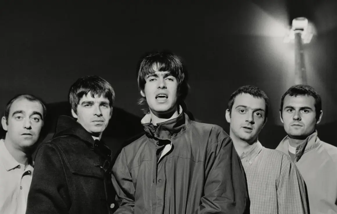 Oto członkowie jednego z najsłynniejszych zespołów rockowych, Oasis, pozujący do zdjęcia.