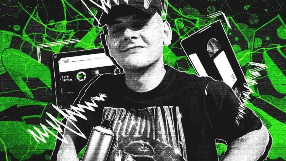 Młody mężczyzna w czapce i koszulce z napisem, obok kaset VHS i magnetofonowych, na tle zielonych abstrakcyjnych wzorów.