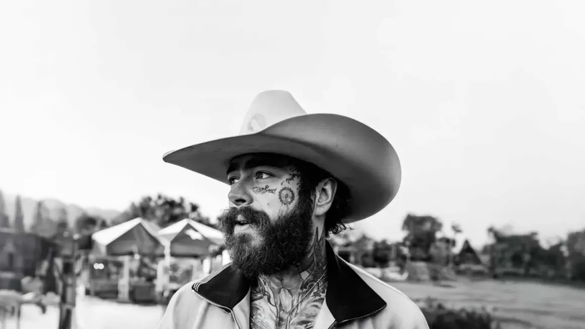 Post Malone w kowbojskim kapeluszu, z tatuażami na twarzy, gotowy na swój kolejny koncert.